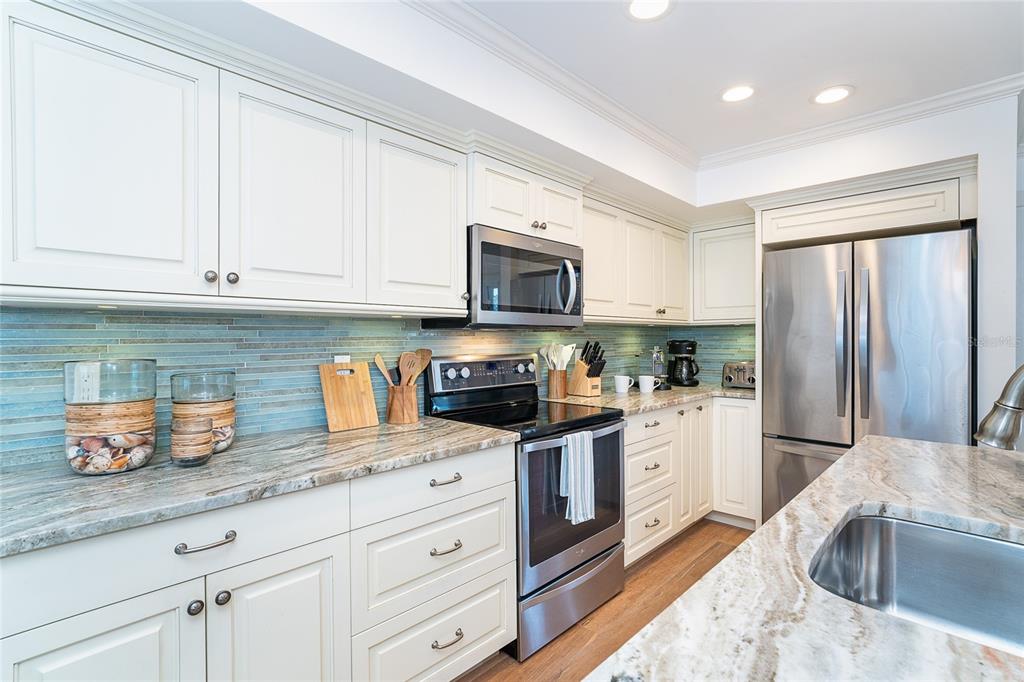 301 South Gulf Boulevard, Unit 25 Placida, FL 33946 - Photo 11 of 68 a kitchen with granite countertop a sink stainless steel appliances and white cabinets