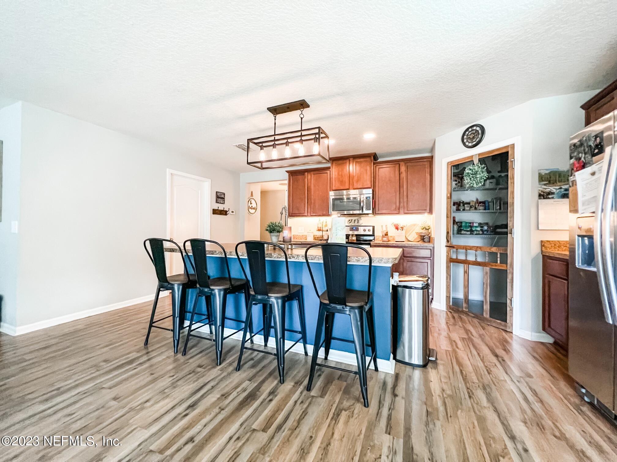 45190 Dutton Way Callahan, FL 32011 - Photo 13 of 29 a kitchen with stainless steel appliances a dining table chairs and wooden floor