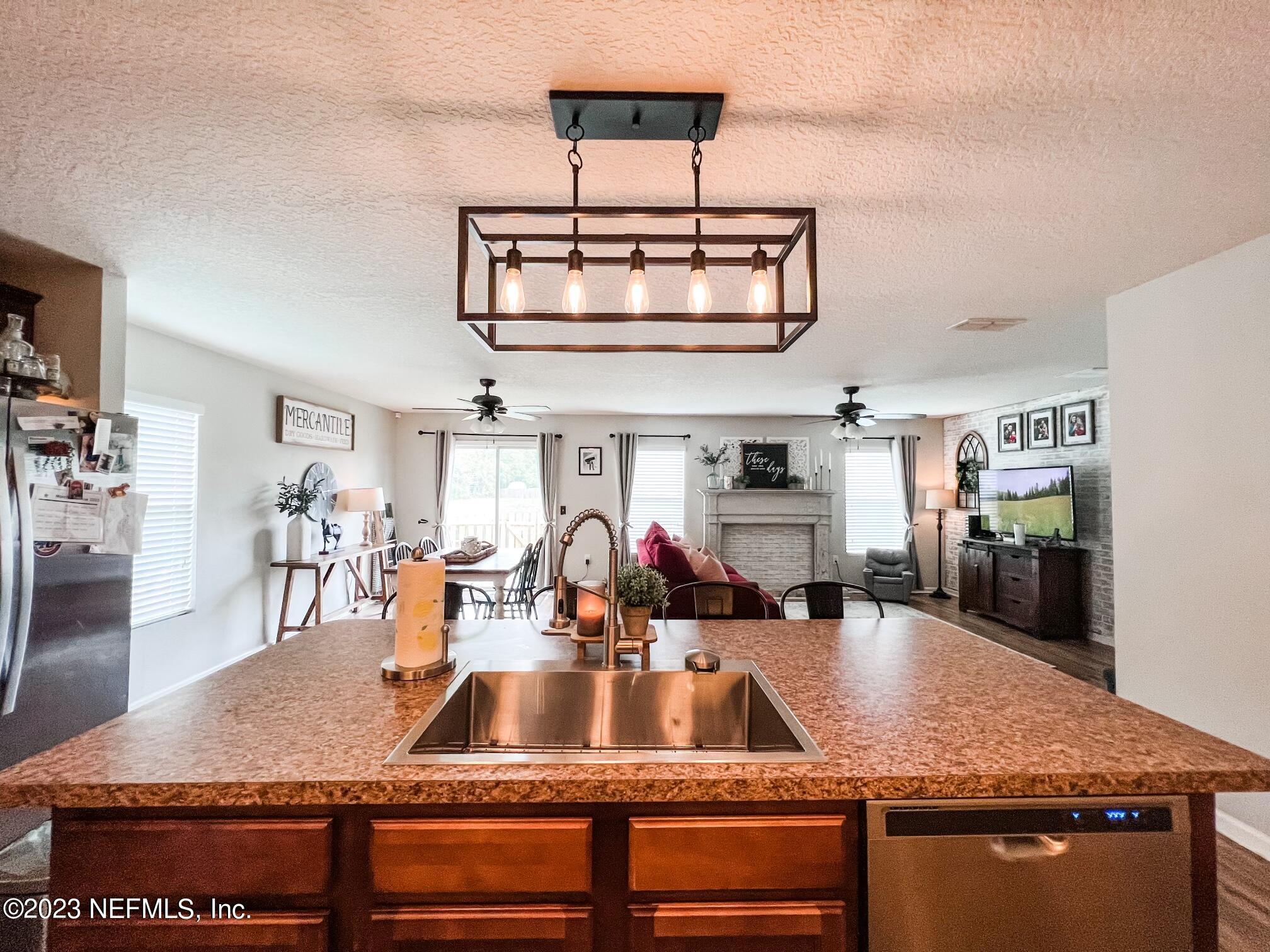 45190 Dutton Way Callahan, FL 32011 - Photo 15 of 29 a kitchen with stainless steel appliances granite countertop a sink dishwasher and cabinets with wooden floor