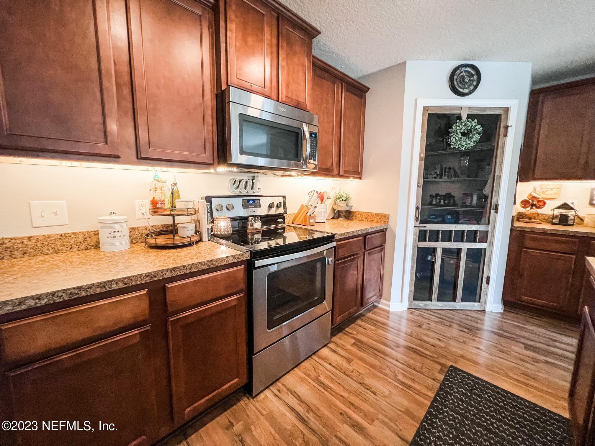 45190 Dutton Way Callahan, FL 32011 - Photo 16 of 29 a kitchen with stainless steel appliances granite countertop a stove a sink and a microwave