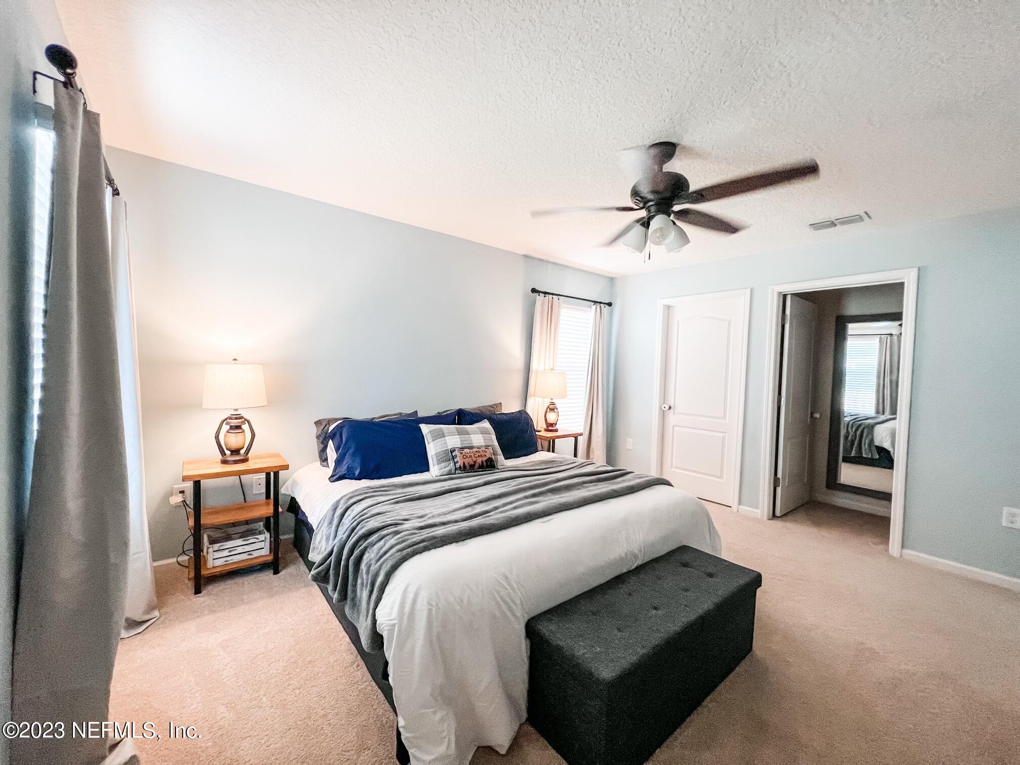 45190 Dutton Way Callahan, FL 32011 - Photo 21 of 29 a bedroom with a bed and a chandelier