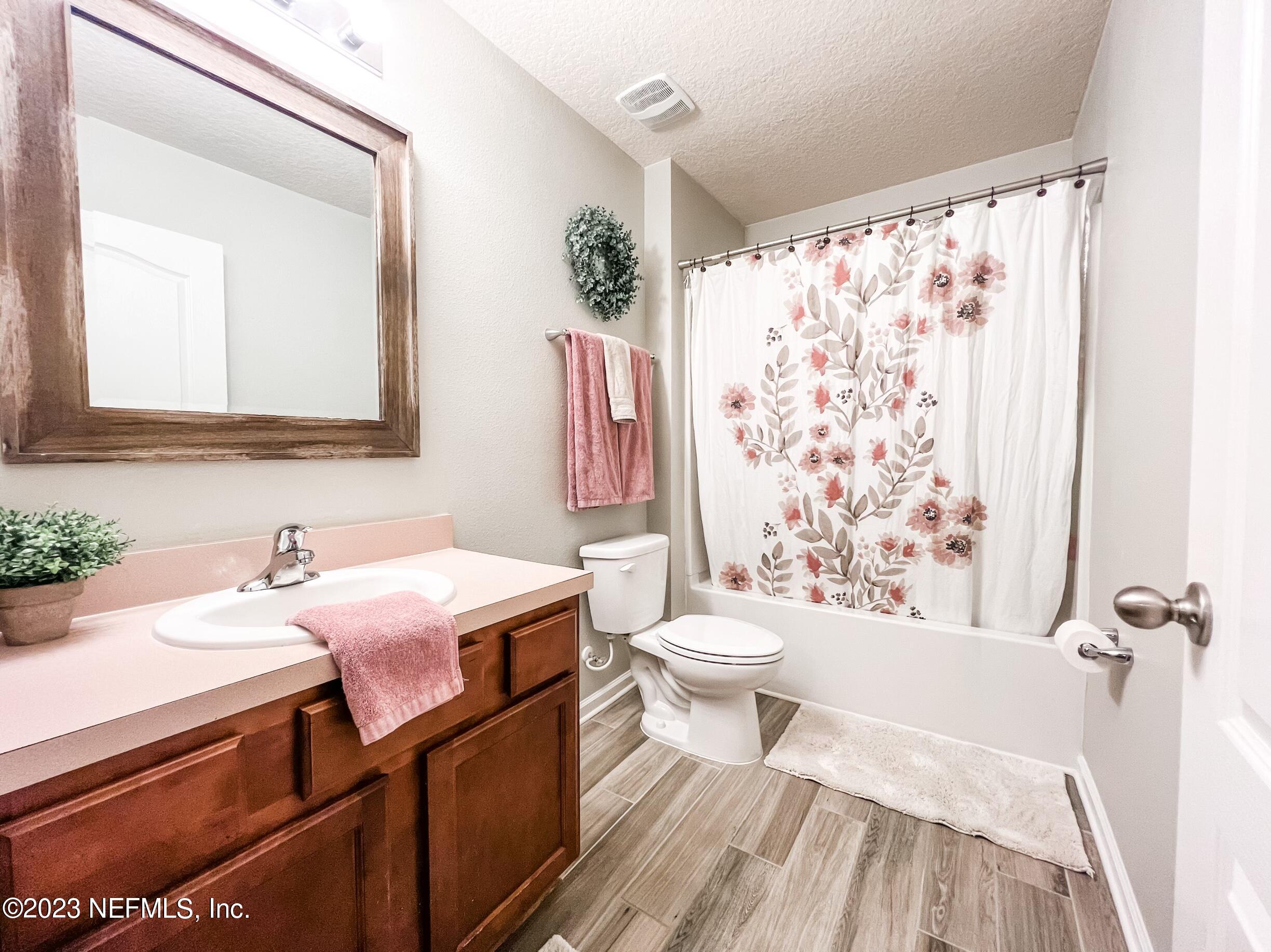 45190 Dutton Way Callahan, FL 32011 - Photo 7 of 29 a bathroom with a sink a toilet and shower curtain