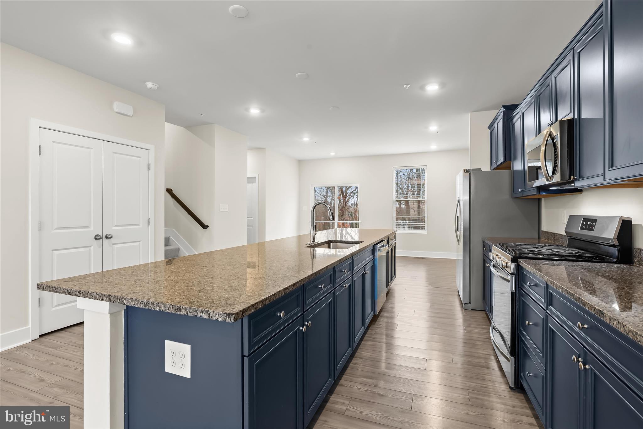 304 Sweetbay Road Essex, MD 21221 - Photo 10 of 66 a kitchen with stainless steel appliances granite countertop a stove top oven a sink dishwasher and wooden cabinets with wooden floor