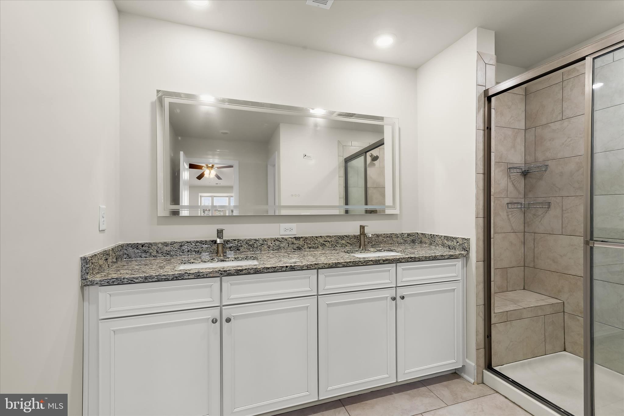 304 Sweetbay Road Essex, MD 21221 - Photo 22 of 66 a bathroom with a granite countertop sink a mirror and a shower