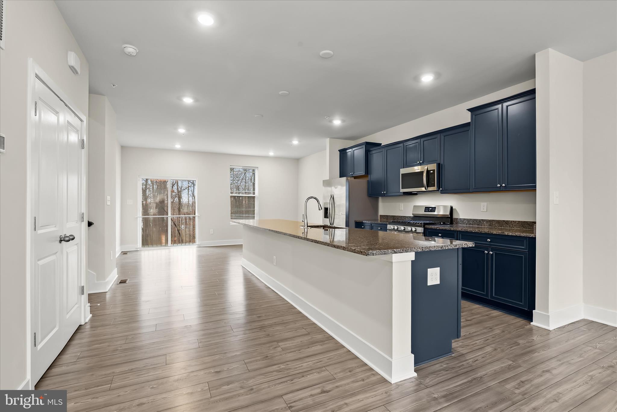 304 Sweetbay Road Essex, MD 21221 - Photo 59 of 66 a kitchen with stainless steel appliances granite countertop wooden cabinets a refrigerator a stove a sink and a oven with wooden floor