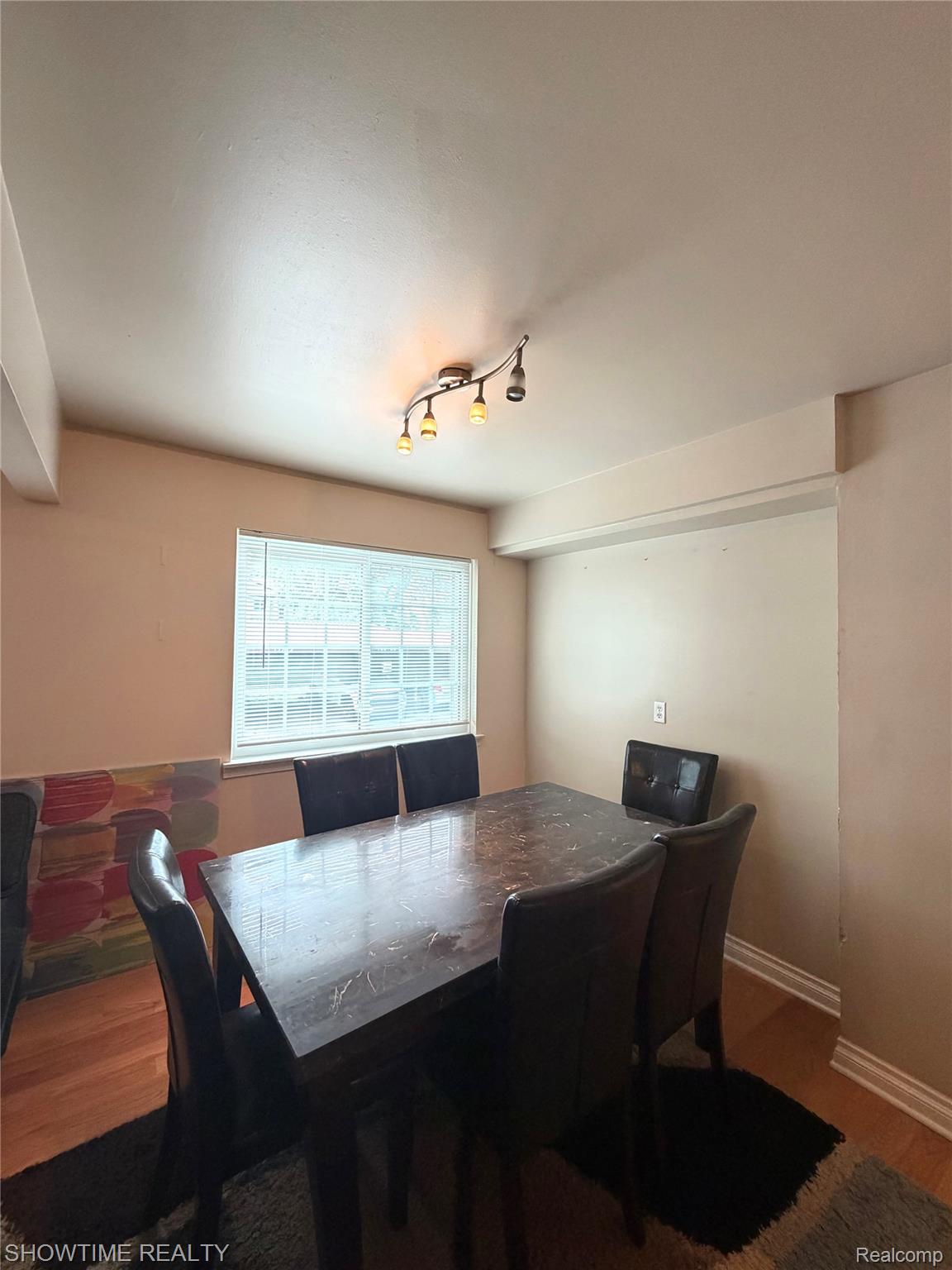 29117 Hayes Road, Unit 3 Warren, MI 48088 - Photo 5 of 14 Dining area featuring wood-finish flooring, a window with horizontal blinds, and a track lighting fixture
