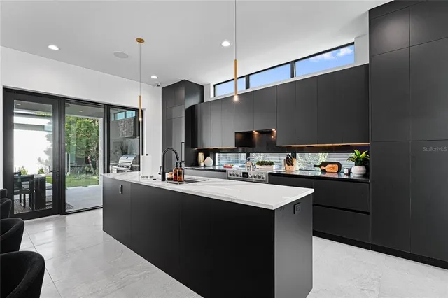 a large kitchen with a counter space a sink stainless steel appliances and cabinets