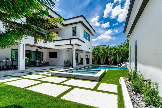 a view of a house with a yard fire pit and a large tree