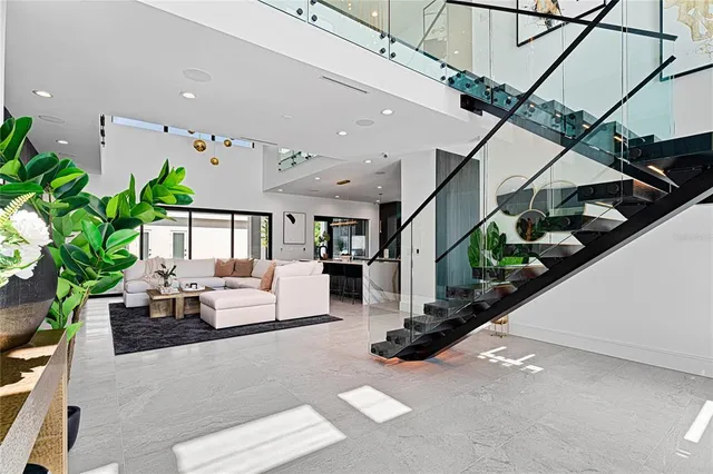 a living room with furniture windows and potted plants