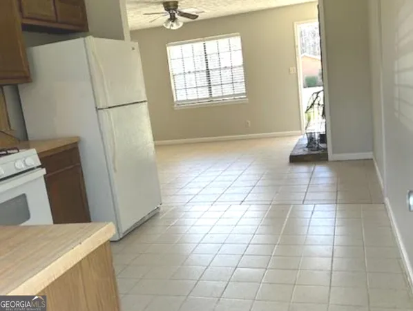 a view of a kitchen with fridge and front door