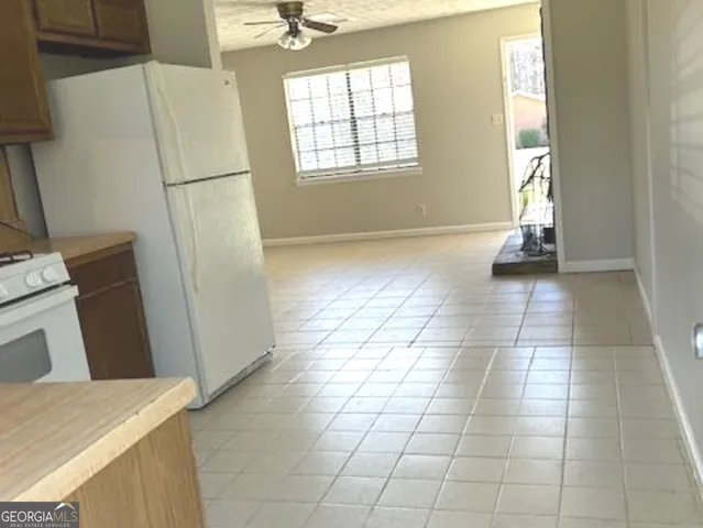a view of a kitchen with fridge and front door