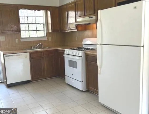 a kitchen with a refrigerator sink stove and cabinets