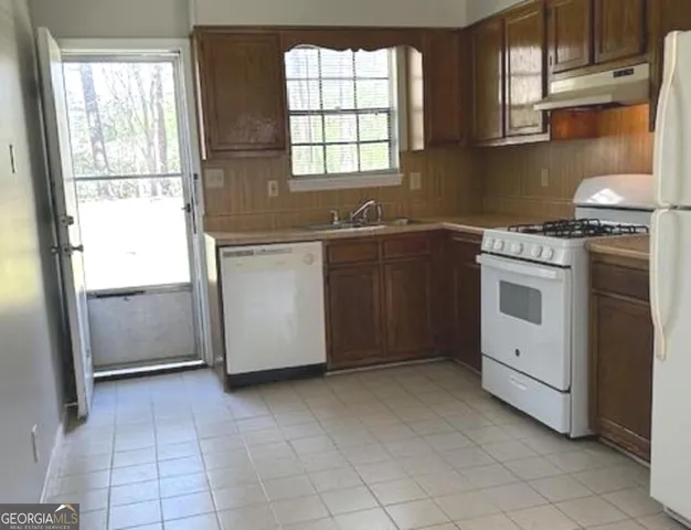 a kitchen with a stove a sink and a refrigerator