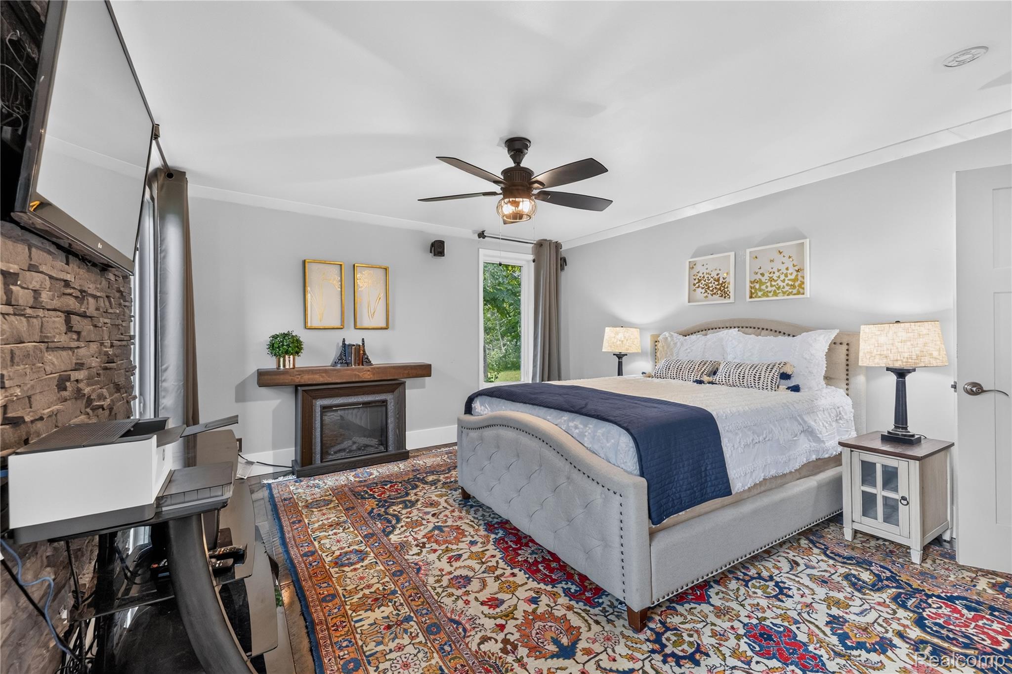4860 Blue Bush Road Monroe, MI 48162 - Photo 22 of 59 Spacious bedroom featuring crown molding, a ceiling fan with integrated lighting, a built-in fireplace with a wood mantle, and a white paneled door