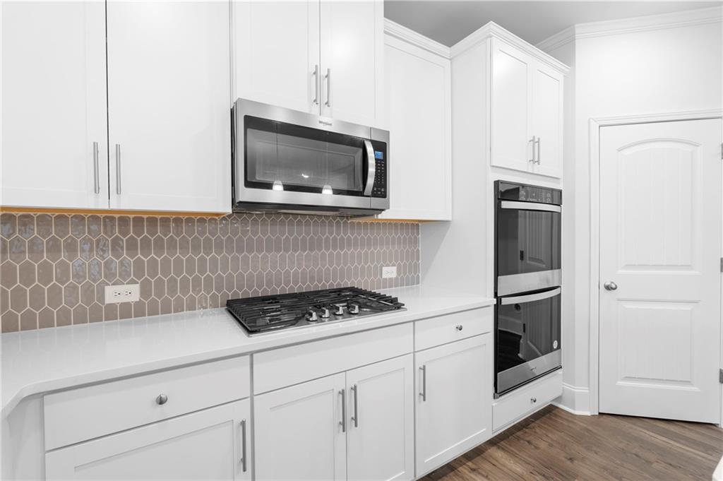 42 Citrine Way Acworth, GA 30101 - Photo 10 of 55 a kitchen with white cabinets stainless steel appliances and wooden floor