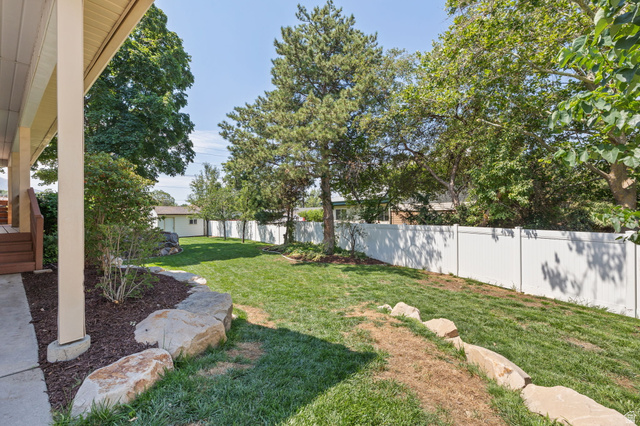 2370 Quail Run Circle East Sandy, UT 84093 - Photo 37 of 54 Expansive backyard featuring a manicured lawn, established trees, and a white privacy fence