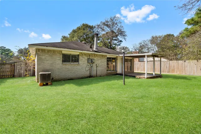 a view of a backyard with a large tree and wooden fence