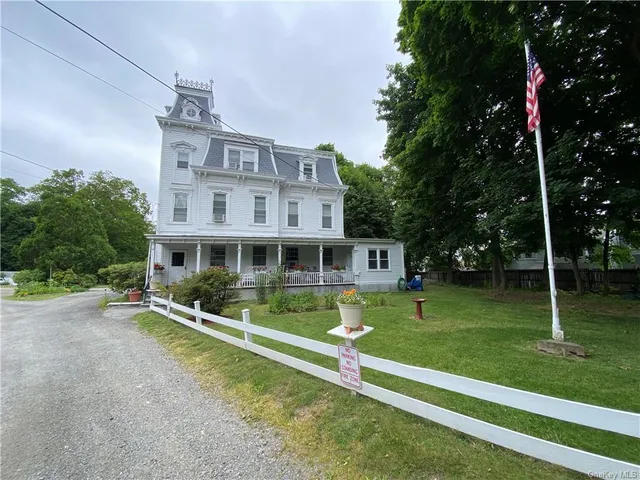a view of a house with a big yard and large trees