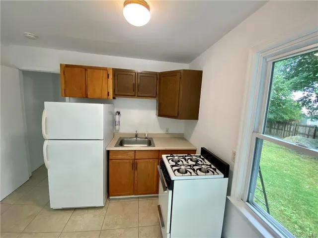 a kitchen with a refrigerator a stove top oven a sink and cabinets