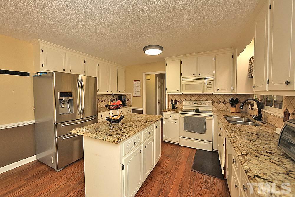 7210 Kemp Road Raleigh, NC 27613 - Photo 3 of 20 a kitchen with granite countertop a refrigerator stove top oven and sink