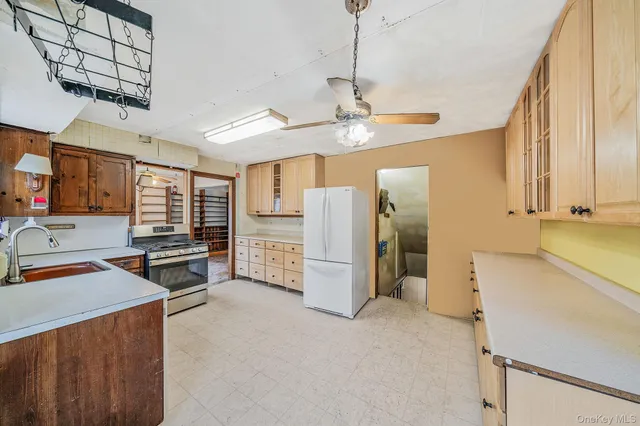 a view of a kitchen with fridge and window