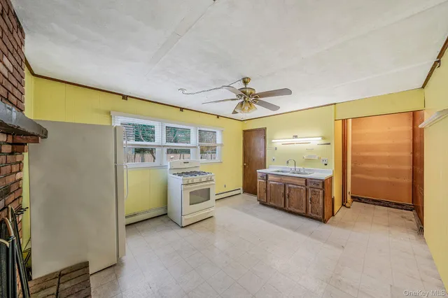 a view of a kitchen with a sink and a refrigerator