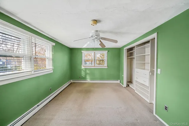 a view of an empty room with a window and a ceiling fan