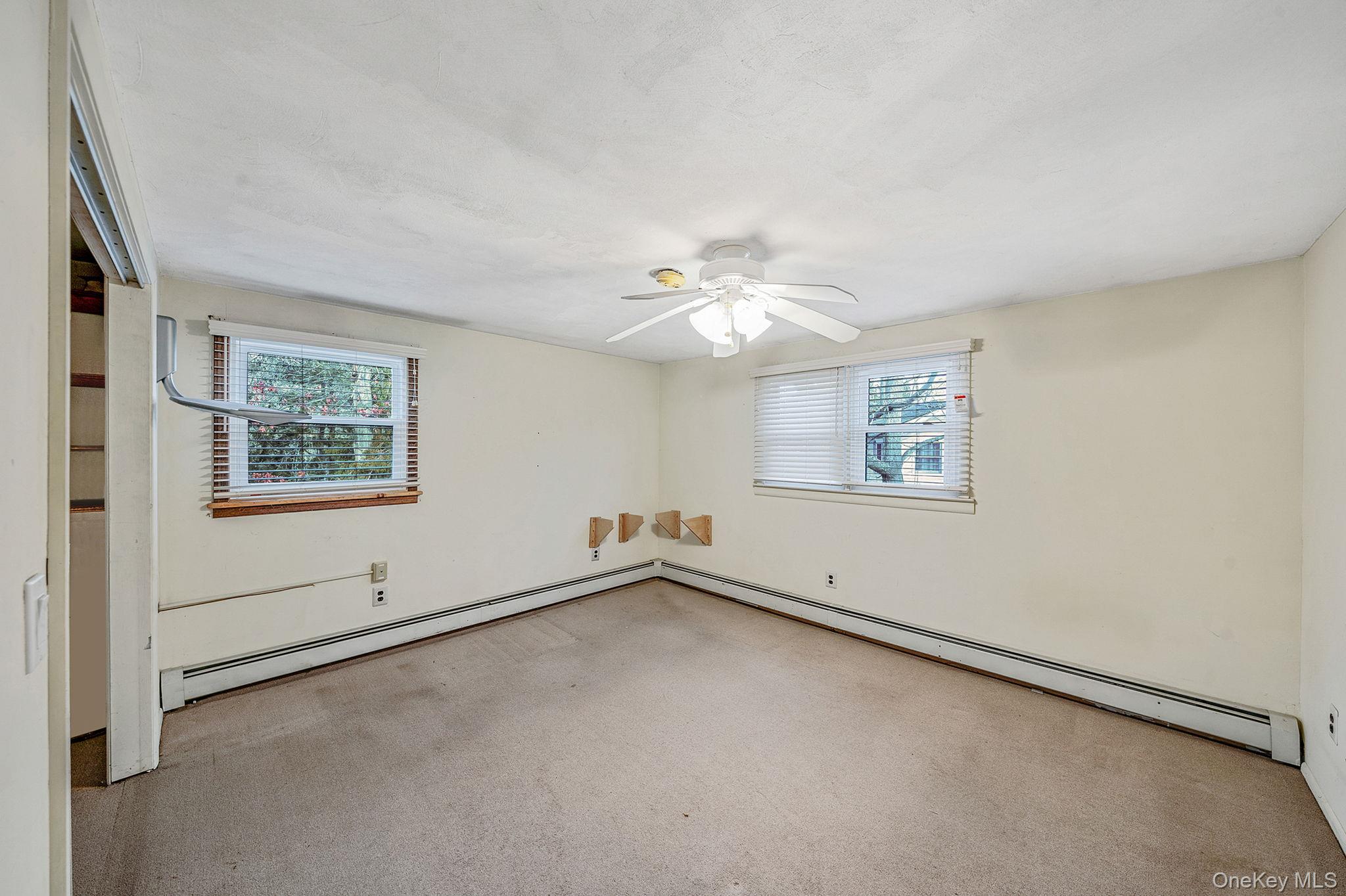 120 Rustic Road Port Jefferson, NY 11777 - Photo 28 of 45 an empty room with windows and chandelier fan