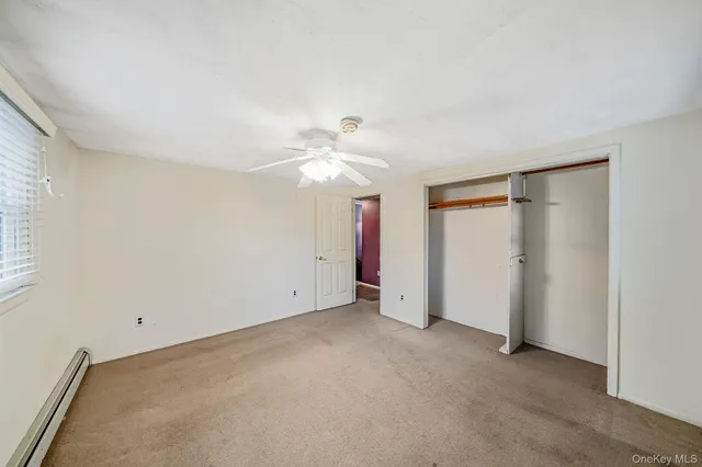 an empty room with a ceiling fan and a window