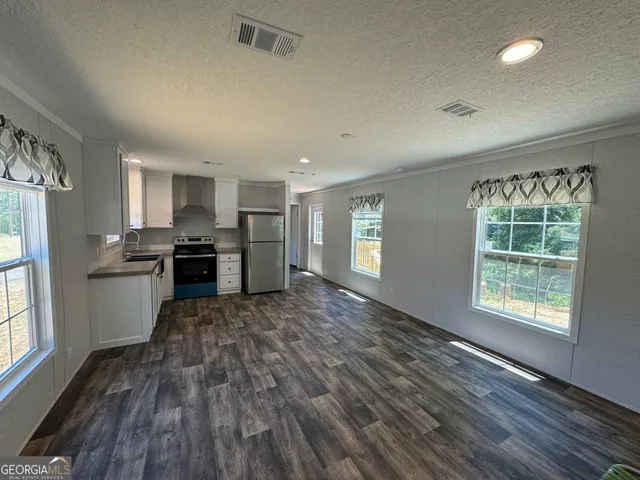 a large kitchen with cabinets wooden floor and stainless steel appliances