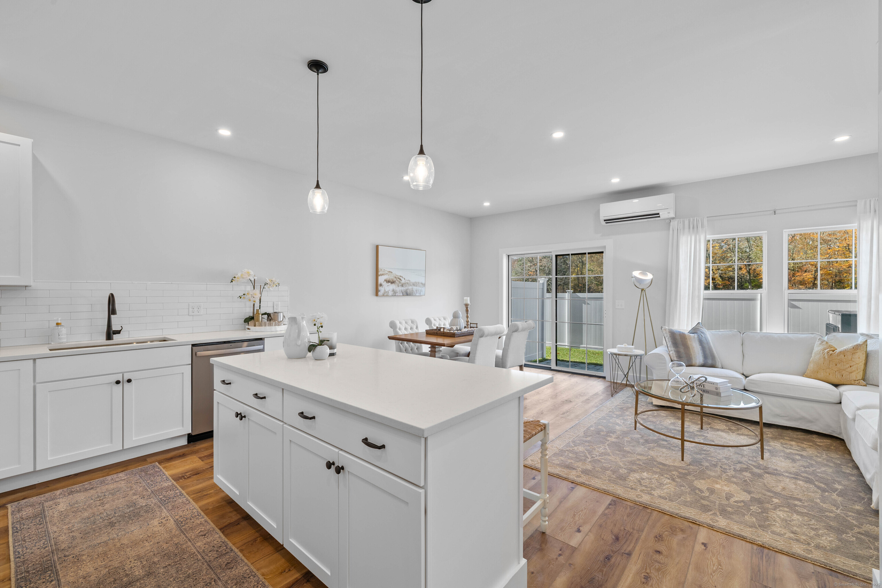 138 Boston Post Road, Unit 16 East Lyme, CT 06333 - Photo 11 of 35 a large white kitchen with a sink and living room view