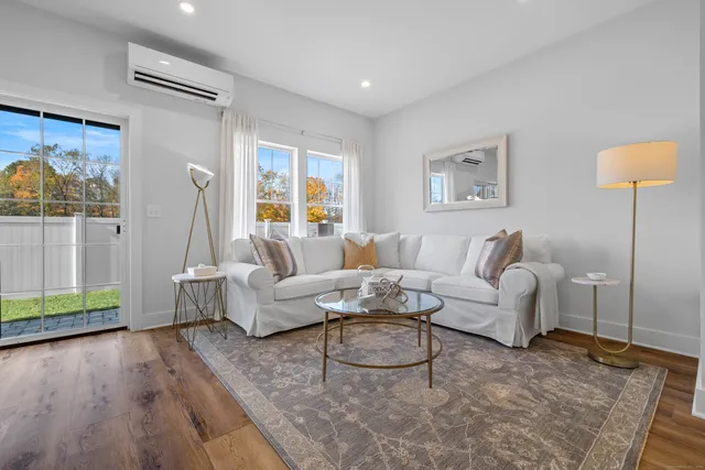 a living room with furniture and a wooden floor