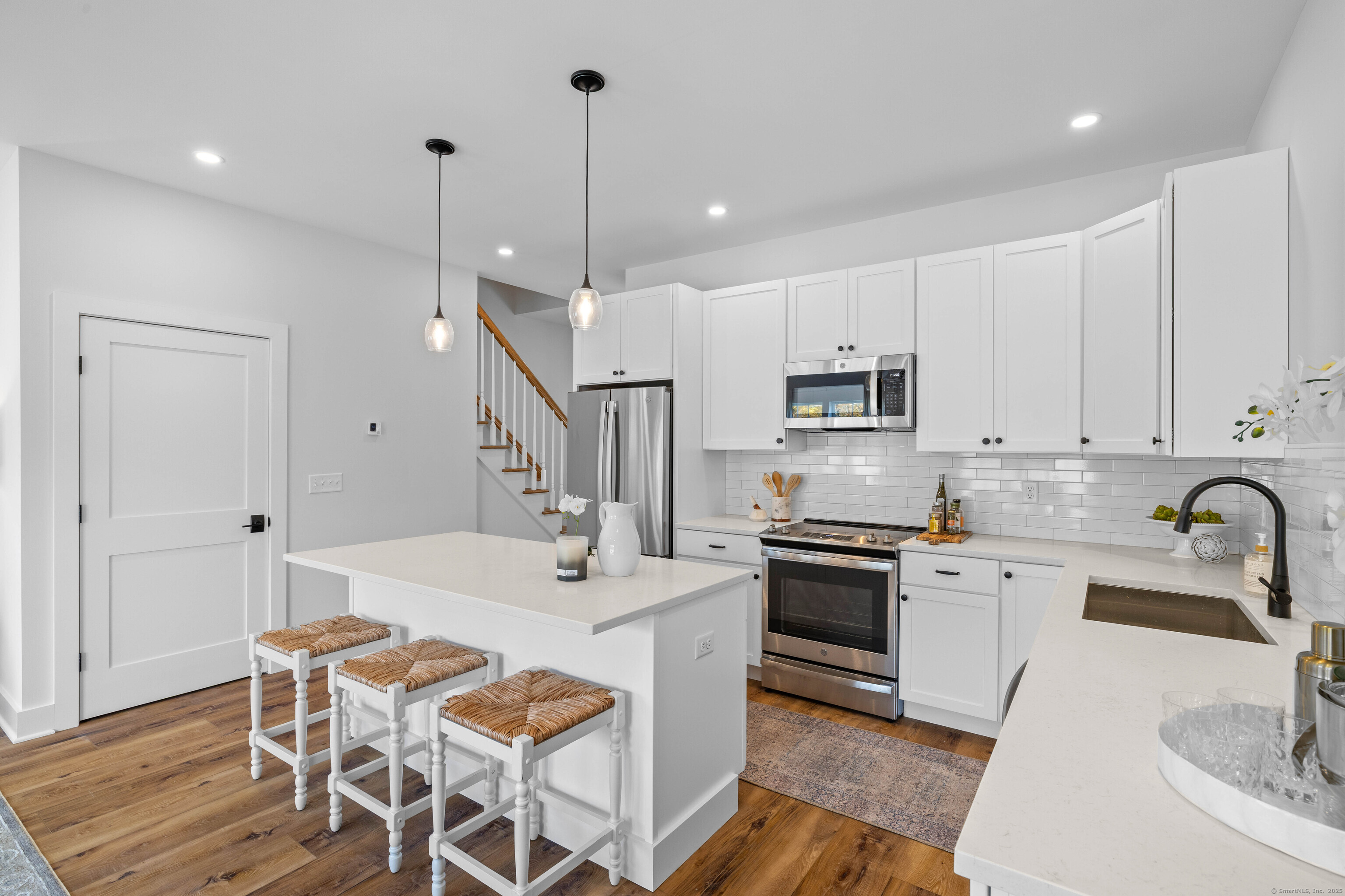 138 Boston Post Road, Unit 16 East Lyme, CT 06333 - Photo 5 of 35 a kitchen with stainless steel appliances kitchen island granite countertop a sink a stove a dining table and chairs