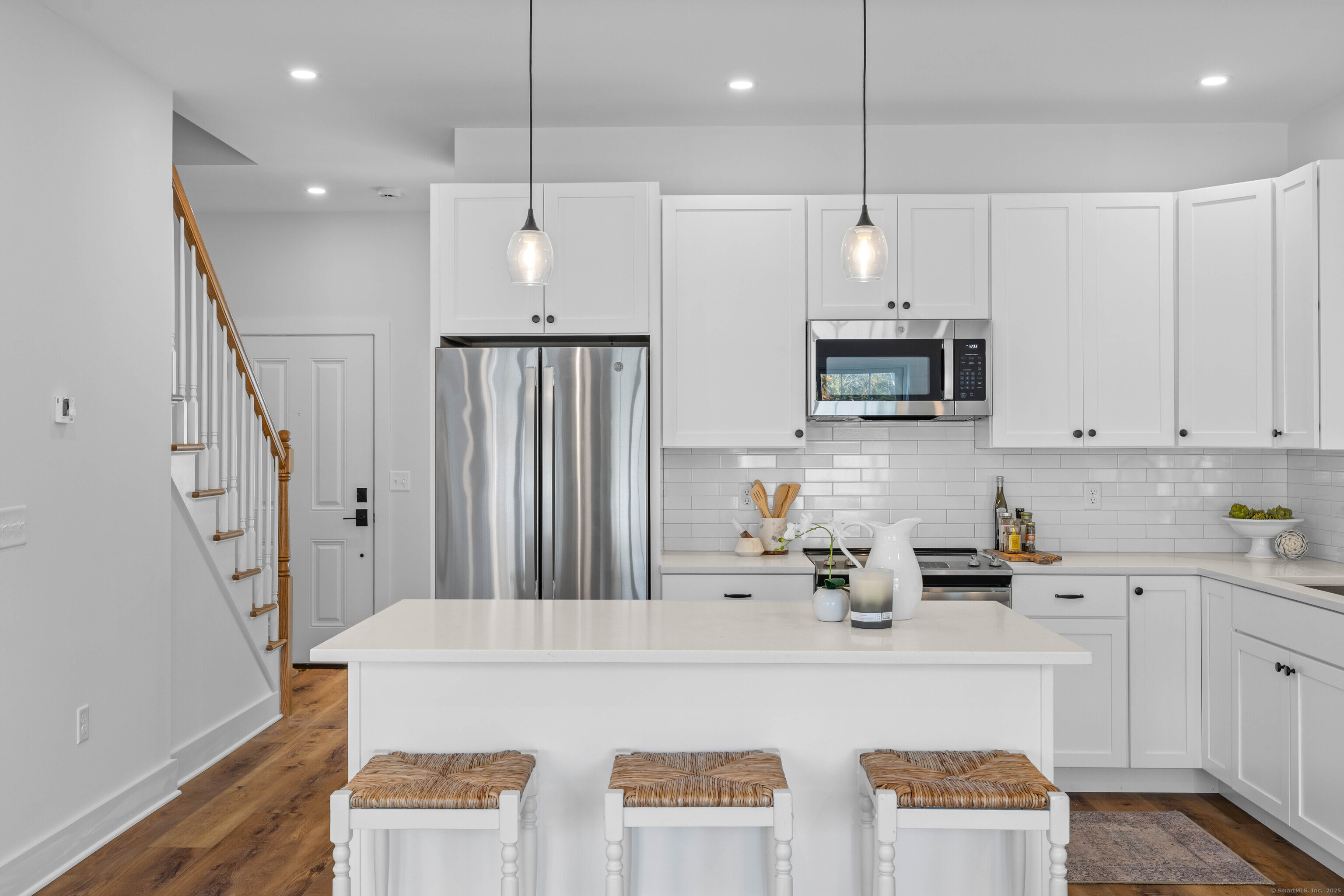 138 Boston Post Road, Unit 16 East Lyme, CT 06333 - Photo 6 of 35 a kitchen with stainless steel appliances granite countertop a refrigerator a sink dishwasher a stove and white cabinets with wooden floor