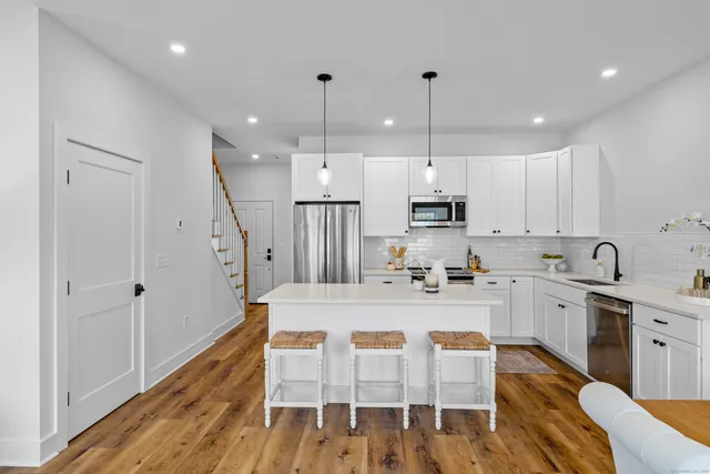 a large kitchen with white cabinets and stainless steel appliances