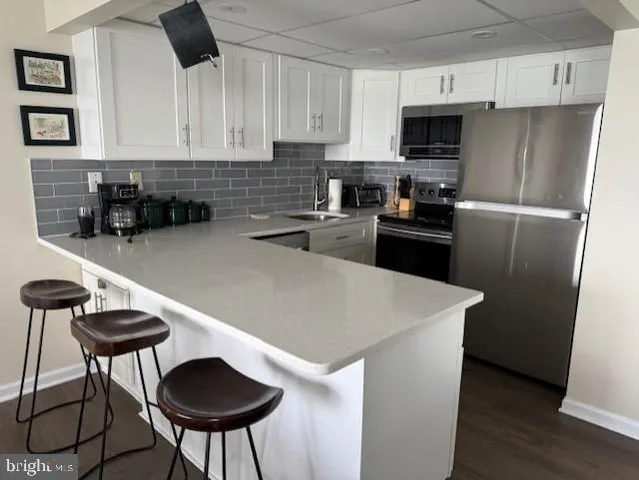 a kitchen with stainless steel appliances a stove a sink a refrigerator and cabinets