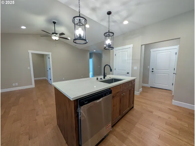an open kitchen with a sink and chandelier