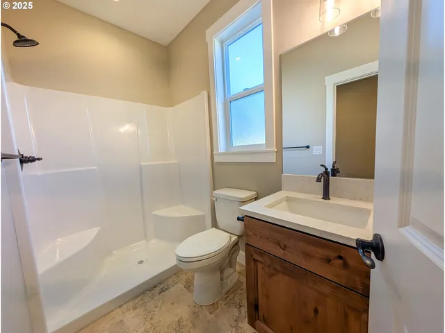 a bathroom with a sink a toilet and shower