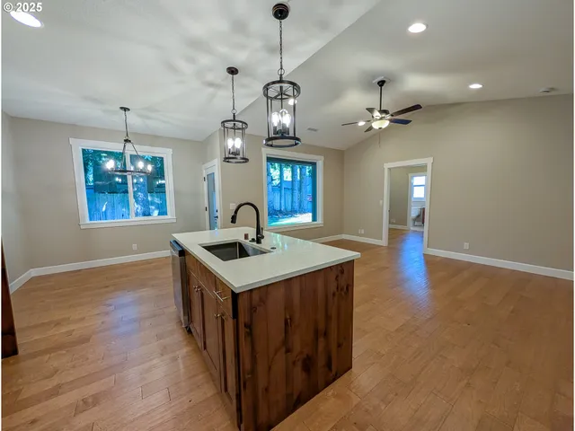 a kitchen with a stove a sink a window and wooden floor