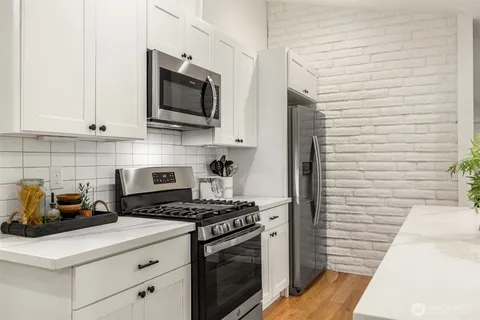 a kitchen with stainless steel appliances a stove microwave and sink