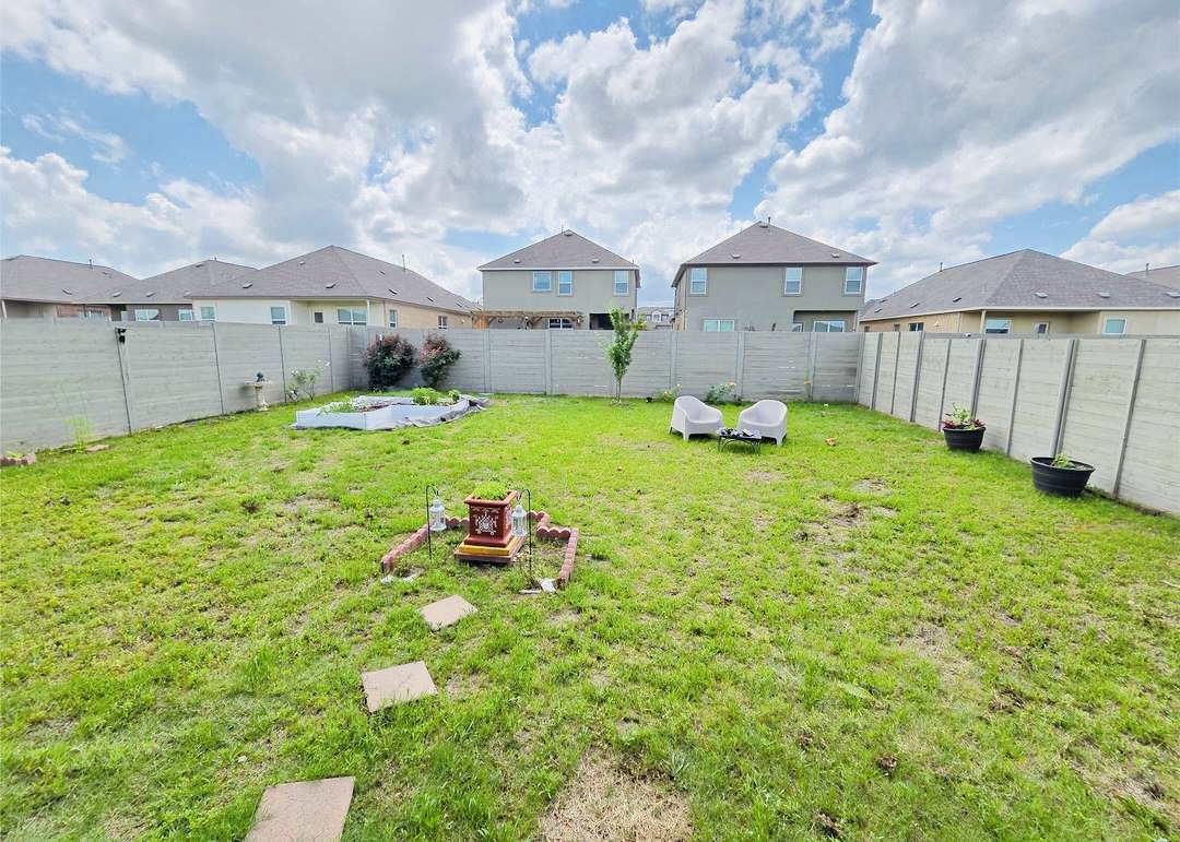 208 Wolf Springs Road Georgetown, TX 78628 - Photo 26 of 32 A spacious, enclosed backyard offers ample green space and a dedicated garden area for outdoor enjoyment.