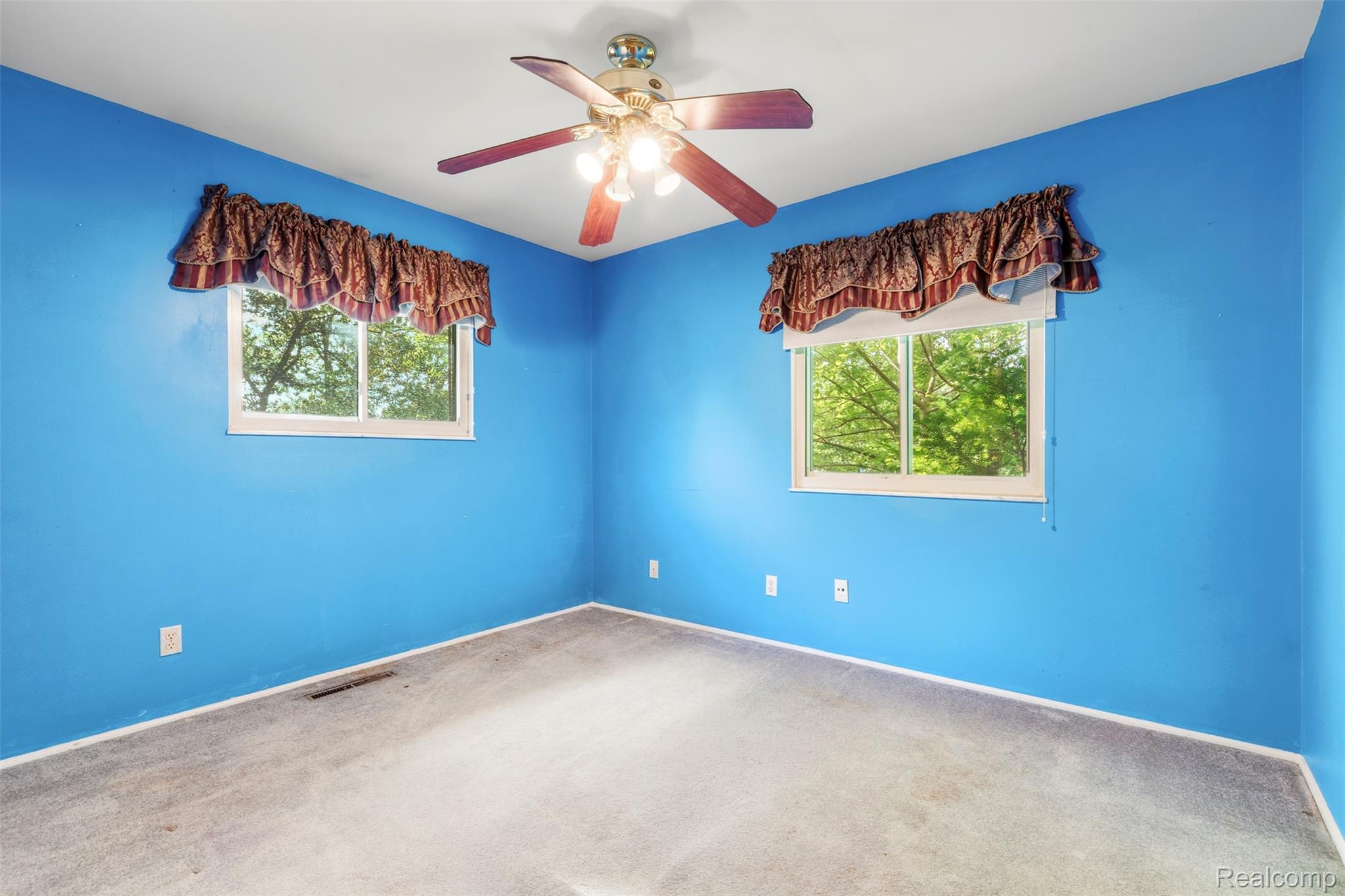 309 Windy Bluff Street Flushing, MI 48433 - Photo 17 of 32 Room featuring two windows, a ceiling fan with integrated lighting, and wall-to-wall carpeting