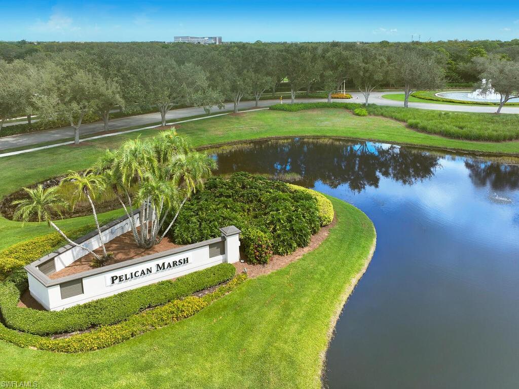1033 Egrets Walk Circle, Unit 203 Naples, FL 34108 - Photo 28 of 35 a view of a lake with a big yard