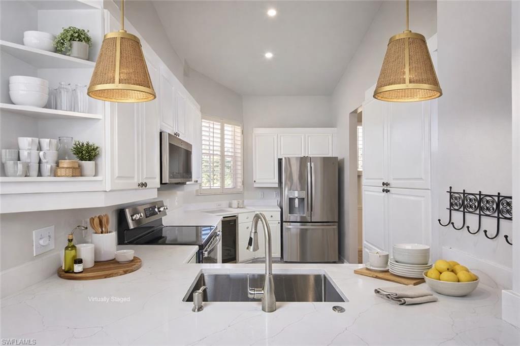 1033 Egrets Walk Circle, Unit 203 Naples, FL 34108 - Photo 3 of 35 a kitchen with stainless steel appliances granite countertop a refrigerator and a sink