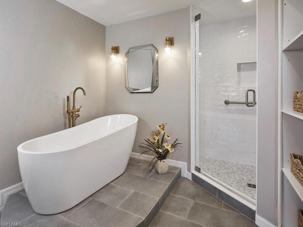 1033 Egrets Walk Circle, Unit 203 Naples, FL 34108 - Photo 7 of 35 a white bath tub sitting next to a bathroom sink