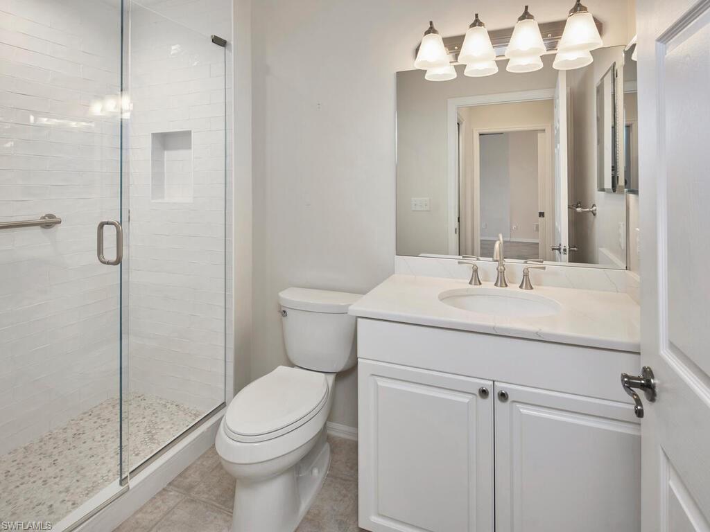 1033 Egrets Walk Circle, Unit 203 Naples, FL 34108 - Photo 9 of 35 a bathroom with a sink toilet and shower