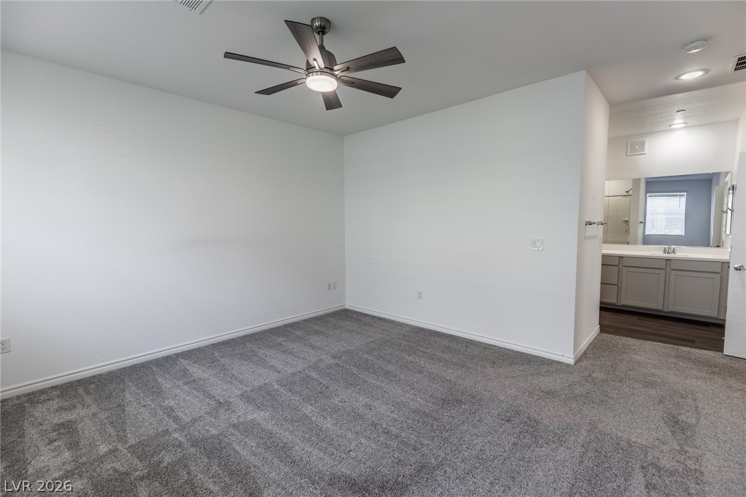 2555 Hampton Road, Unit 8206 Henderson, NV 89052 - Photo 12 of 35 This spacious primary bedroom features soft carpeting and direct access to a private en-suite bathroom.