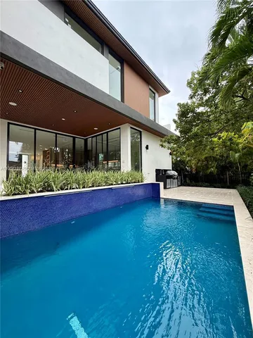 a view of a house with pool yard and outdoor seating