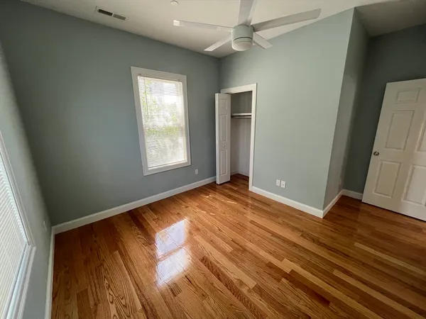 an empty room with wooden floor and window