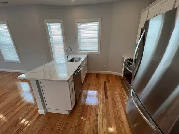 a view of a kitchen with wooden floor and staircase